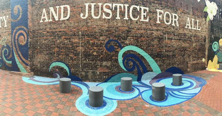 mural painted on a brick wall including the words and justice for all